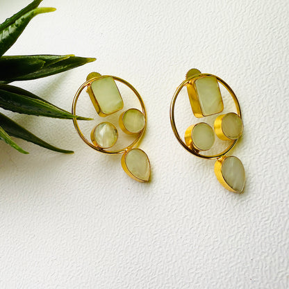 Gold earrings with green stones on a white background