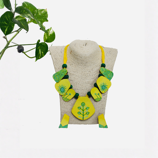 Necklace with green and yellow design on a mannequin bust against a white background