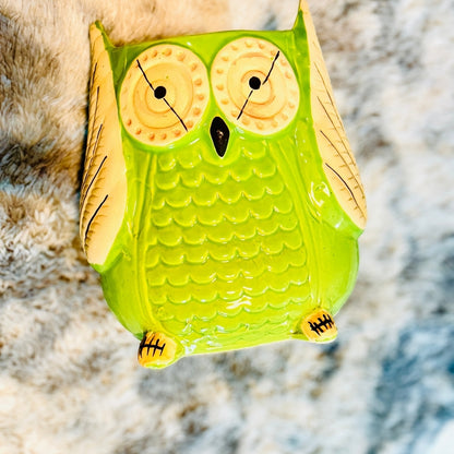 Green owl-shaped object on a textured surface