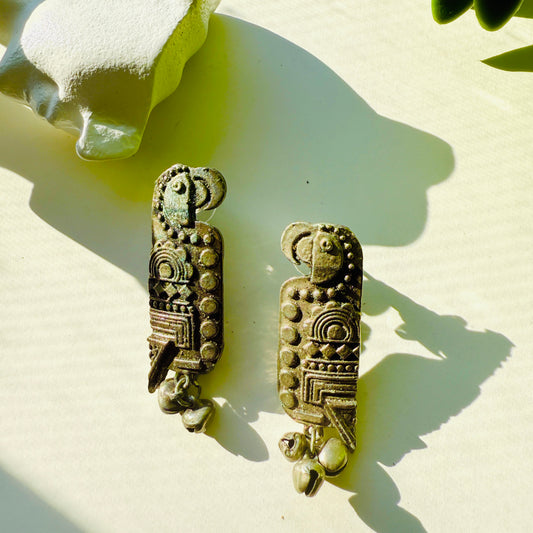 Pair of decorative earrings with intricate designs on a light background