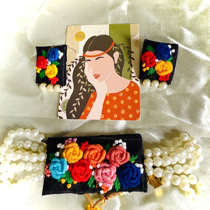 Decorative hair clips with floral designs and pearls on a white fabric background