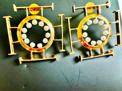 Two gold and white circular objects on a dark background