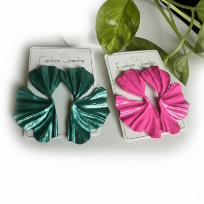 Two pairs of green and pink scrunchies on 'Fashion Jewelry' cards with a plant in the background.