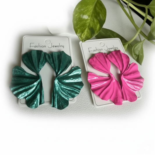 Two pairs of green and pink scrunchies on 'Fashion Jewelry' cards with a plant in the background.