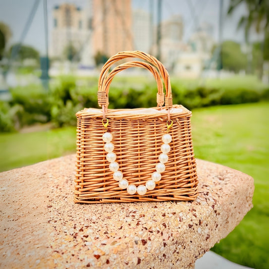 Handmade straw beach bag with large pearl detailing for a chic and trendy look