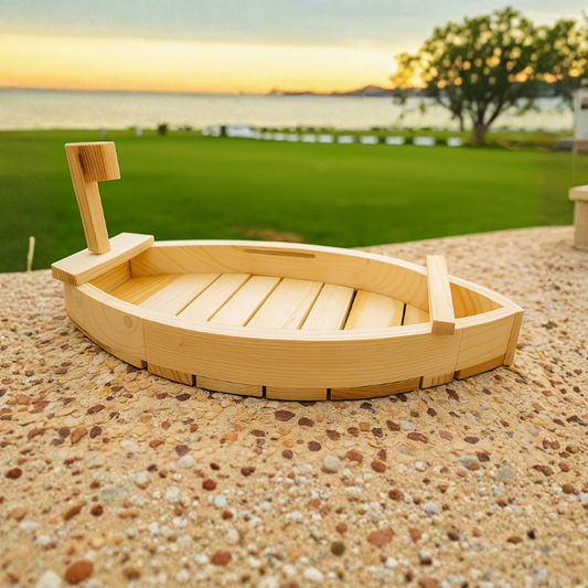 Wooden toy boat on a pebbled surface with a scenic background