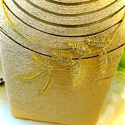 Gold-wrapped cylindrical object with leaf designs on a white background