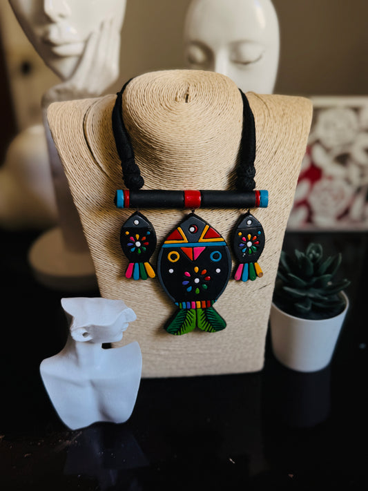 Colorful fish-shaped necklace on a mannequin bust with a blurred background