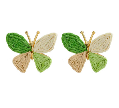 Butterfly-shaped earrings with green and beige wings on a white background